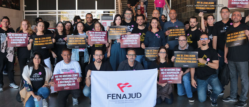 Imagem Acessível: Grupo de pessoas com cartazes de protesto contra o Regime de Recuperação Fiscal (RRF), duas pessoas em primeiro plano exibem a bandeira da Fenajud. Estão presentes os diretores do Serjusmig e do SINJUS-MG. Representando o SINJUS estão Alexandre Pires, coordenador-geral, Felipe Rodrigues, Alexandre Pires, Janaína Torres e o servidor Wagner Ferreira. Conteúdo textual: ALTERNATIVAS À VISTA - STF prorroga prazo da dívida e votação do RRF é adiada novamente