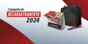 Imagem Acessível: A imagem apresenta uma campanha de recadastramento para 2024. O visual é marcado por um fundo em tons de vermelho e branco. No centro, há um kit do SINJUS composto por um calendário de mesa para 2025, uma mochila preta e uma caneta personalizada. A mensagem destaca que, ao atualizar os dados, a pessoa receberá esse kit diretamente em sua casa. O calendário exibe a frase "Sindicato é pra lutar!" e a mochila possui um detalhe comemorativo dos 30 anos da instituição.