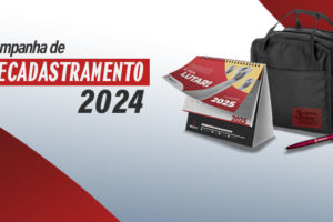 Imagem Acessível: A imagem apresenta uma campanha de recadastramento para 2024. O visual é marcado por um fundo em tons de vermelho e branco. No centro, há um kit do SINJUS composto por um calendário de mesa para 2025, uma mochila preta e uma caneta personalizada. A mensagem destaca que, ao atualizar os dados, a pessoa receberá esse kit diretamente em sua casa. O calendário exibe a frase "Sindicato é pra lutar!" e a mochila possui um detalhe comemorativo dos 30 anos da instituição.