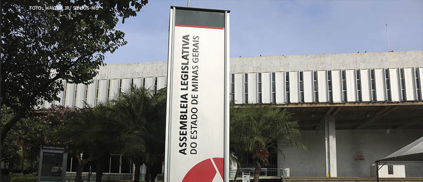 Fotografia diurna da fachada da Assembleia Legislativa de Minas Gerais (ALMG) com foco na placa vertical da mesma.