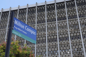 Fotografia diurna da fachada da unidade do TJMG localizada na Praça Milton Campos, ao lado se vê a placa da praça Milton Campos.