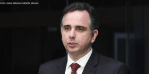 Imagem acessível: Fotografia do presidente do Congresso Nacional, senador Rodrigo Pacheco, um homem de pele clara, cabelo curto preto, com vestimentas formais (terno preto e gravata vermelha).
