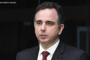 Imagem acessível: Fotografia do presidente do Congresso Nacional, senador Rodrigo Pacheco, um homem de pele clara, cabelo curto preto, com vestimentas formais (terno preto e gravata vermelha).