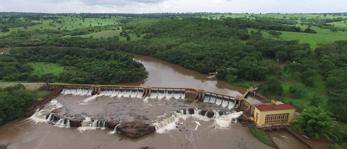 Foto aérea da Pequena Central Hidrelétrica Salto Morais, pertencente à Cemig. A usina fica no Rio Tijuco, que tem águas escuras e fica em meio a uma área verde.