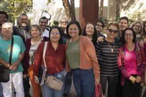 Fotografia da reunião do NAP no Ancionato bemviver, com os integrantes e os diretores (Alex Aguiar, Adriana Gonçalves, Janaína Torres) todos estão sorrindo e próximos uns dos outros, transmitindo uma sensação de união. Eles estão vestidos de forma casual, com roupas de cores variadas.