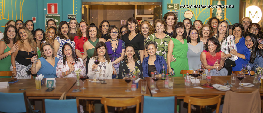 As imagens mostram a confraternização do Núcleo das Mulheres, onde um grupo diverso de mulheres celebra um ciclo em um restaurante, sentadas em mesas compridas e alegres, segurando taças de vinho. Elas aparecem bem arrumadas, sorrindo e interagindo entre si. O ambiente tem uma decoração acolhedora e vibrante, com detalhes coloridos nas paredes. A atmosfera é festiva, destacando a união e o espírito colaborativo do grupo.