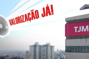 A imagem contém uma crítica em relação às comemorações do "Dia do Servidor" promovidas pelo TJMG. O texto central diz: "TJMG promove 'comemorações' do Dia do Servidor, mas categoria não tem o que celebrar", com o trecho destacado em vermelho, dando ênfase à insatisfação. Abaixo, uma mão segura um megafone, de onde sai a mensagem: "VALORIZAÇÃO JÁ!" em letras grandes e vermelhas. Ao fundo, há uma foto de um prédio do TJMG e da paisagem urbana de Belo Horizonte.